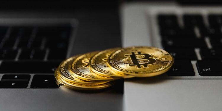 Stack of Bitcoins on top of two laptops