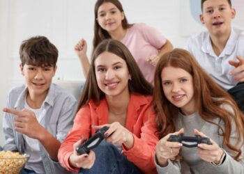 Neon-lit close-up of a female video gamer, wearing headphones, engrossed in playing a video game on her PC.