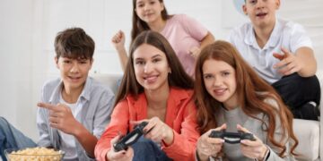 Neon-lit close-up of a female video gamer, wearing headphones, engrossed in playing a video game on her PC.